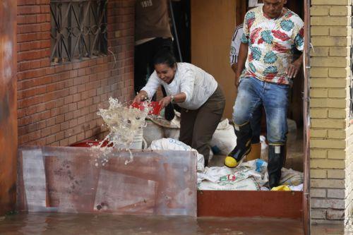 epa12834956 A woman removes water from her house onto a street flooded by heavy rains in Facatativa, Colombia, 19 March 2026. According to the mayor of Facatativa, Luis Carlos Casas, and local emergency agencies, heavy rains caused the Mancilla and San Rafael creeks to overflow and feed the Botello River, leading to severe flooding that affected more than...
