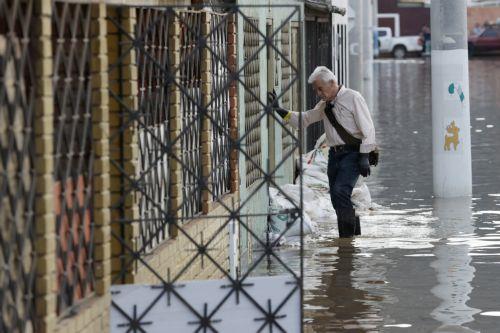 epa12834960 A man wades through a flooded street after  heavy rains in Facatativa, Colombia, 19 March 2026. According to the mayor of Facatativa, Luis Carlos Casas, and local emergency agencies, heavy rains caused the Mancilla and San Rafael creeks to overflow and feed the Botello River, leading to severe flooding that affected more than 2,000 families. ...