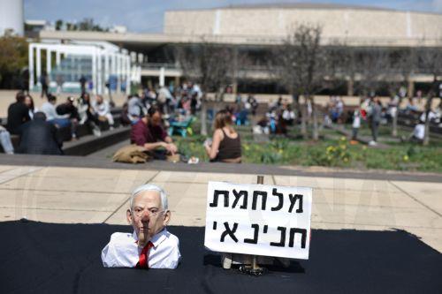 epa12835878 A puppet resembling Israeli prime minister Benjamin Netanyahu is placed next to a sign reading in Hebrew 'Haninai War' referring to the Hebrew word Hanina ('pardon' in English) as anti-government protesters stage a protest against the war with Iran calling for the end of the war, in Tel Aviv, Israel, 20 March 2026. US and Israel launched a joint...
