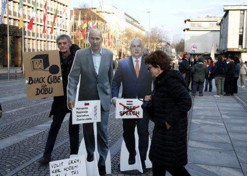 epa12837178 People pose with cut-outs of Hungarian Prime Minister Viktor Orban and former Slovenian Prime Minister and leader of Slovenian Democratic party (SDS) Janez Jansa outside the American Embassy in downtown Ljubljana, Slovenia, 20 March 2026. The 22 March 2026 parliamentary election will take place as reports of an alleged covert operation by a...