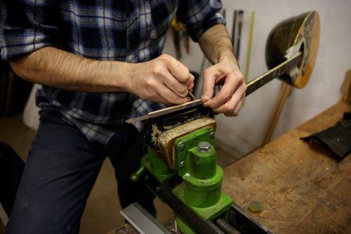 epa12838009 Panagiotis Toulikas, a maker of handmade stringed instruments, works on installing the tuning pegs upon the headstock of a bouzouki, in his workshop in Exarcheia district, Athens, Greece, 26 February 2026 (issued 21 March 2026). Panagiotis Toulikas specializes in building  guitars and bouzoukis; he believes that experienced performers prefer...