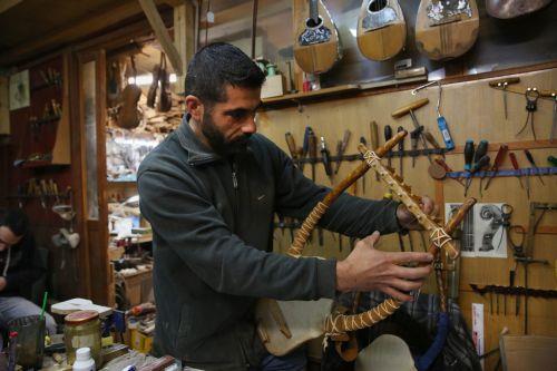 epa12838016 Hercules Bras adjusts the tuning pegs on a lyre under construction in his father’s workshop, where handmade stringed instruments have been crafted for 40 years, in Athens, Greece, 26 February 2026 (issued 21 March 2026). The Bras family workshop, besides violin-family instruments, specializes also in making scientifically reconstructed replicas...