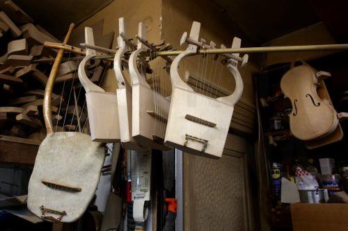 epa12838020 Lyres and kitharas hang before their completion in the workshop of Nikolas Bras and his sons, Socrates and Hercules, where handmade stringed instruments have been crafted for 40 years, in Athens, Greece, 26 February 2026 (issued 21 March 2026). The Bras family workshop, besides violin-family instruments, specializes also in making scientifically...