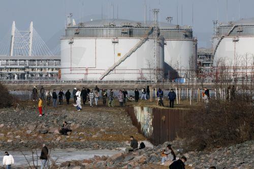 epa12841568 People walk on the shore of the Gulf of Finland with the St. Petersburg Oil Terminal in the background on a sunny day in St. Petersburg, Russia, 22 March 2026. Temperatures in St. Petersburg, Russia's second largest city, reached eleven degrees Celsius.  EPA/ANATOLY MALTSEV