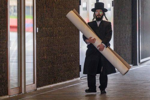 epa12843690 A member of the Jewish community carries a carpet in Antwerp, Belgium, 23 March 2026. The Belgian government announced on 16 March that it will deploy military personnel to reinforce the Federal Police to protect a number of synagogues and Jewish schools across the country following a series of antisemitic attacks in Europe.  EPA/OLIVIER MATTHYS