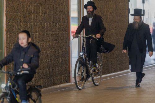 epa12843691 Members of the Jewish community ride their bikes in Antwerp, Belgium, 23 March 2026. The Belgian government announced on 16 March that it will deploy military personnel to reinforce the Federal Police to protect a number of synagogues and Jewish schools across the country following a series of antisemitic attacks in Europe.  EPA/OLIVIER MATTHYS