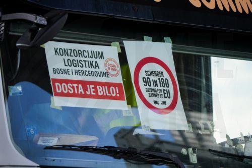 epa12844278 A banner on a truck windshield reads 'It's enough!' during the blockade of the Svilaj border crossing between Bosnia and Herzegovina and Croatia near Donji Svilaj, Bosnia and Herzegovina, 23 March 2026. All border crossings in the country are blocked to freight traffic as carriers suspend transit toward the European Union in opposition to the...