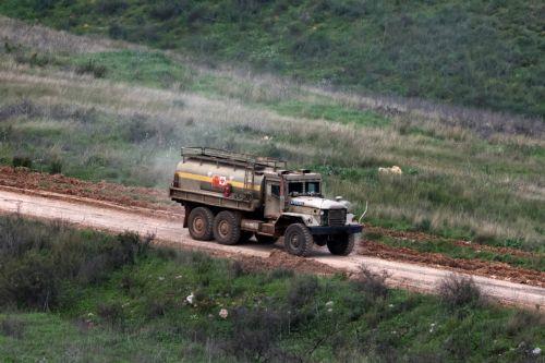 epa12846544 An Israeli military vehicle drives on the Lebanese side of the border, as seen from the Upper Galilee, northern Israel, 24 March 2026. The Israeli military stated it is conducting strikes across Lebanon targeting Hezbollah infrastructure and personnel.  EPA/ATEF SAFADI