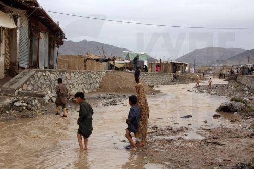 epa12851055 Residents wade through floodwaters after heavy rains in Kandahar, Afghanistan, 26 March 2026. At least ten people died and  six others were injured, while dozens of homes were destroyed and thousands of acres of farmland were severely damaged due to heavy rains and flooding in Kandahar and Helmand, according to Afghan officials.  EPA/QUDRATULLAH...