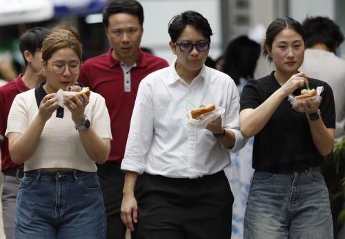 epa12859929 Thai office workers cool off with ice cream during hot weather in Bangkok, Thailand, 30 March 2026. The Meteorological Department reports that Thailand is experiencing extreme heat and urges the public to avoid outdoor activity while the Digital Economy and Society Ministry warns the country's heat index is forecasted to soar to a...