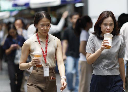 epa12859935 Thai female office workers cool off with cold drinks during hot weather in Bangkok, Thailand, 30 March 2026. The Meteorological Department reports that Thailand is experiencing extreme heat and urges the public to avoid outdoor activity while the Digital Economy and Society Ministry warns the country's heat index is forecasted to soar to a...
