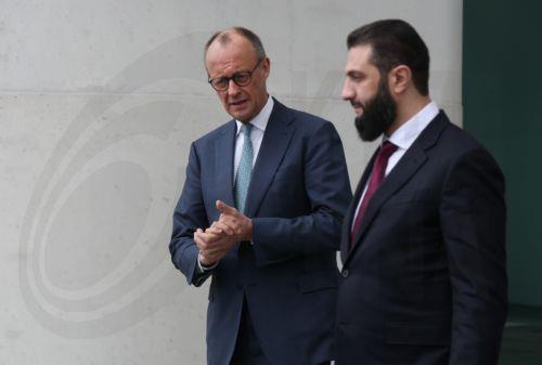 epa12860004 German Chancellor Friedrich Merz (L) and Syrian President Ahmed al-Sharaa (R) walk on the terrace of the Chancellery prior to talks in Berlin, Germany, 30 March 2026. The Syrian president is on his first official state visit to Germany.  EPA/SEAN GALLUP / POOL