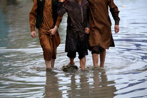 epa12860014 Children wade through a flooded street during a heavy rainy day in Peshawar, Pakistan, 30 March 2026. At least nine people were killed and several others injured after heavy rains and strong winds caused roof collapses in parts of Khyber Pakhtunkhwa and Punjab, with Bannu among the worst affected. Rescue efforts are ongoing, and authorities have...