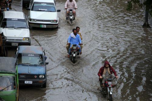 epa12860015 Vehicles drive along a flooded road during heavy rain in Peshawar, Pakistan, 30 March 2026. At least nine people were killed and several others injured after heavy rains and strong winds caused roof collapses in parts of Khyber Pakhtunkhwa and Punjab, with Bannu among the worst affected. Rescue efforts are ongoing, and authorities have warned of...