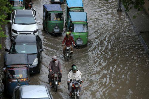 epa12860017 Vehicles drive along a flooded road during heavy rain in Peshawar, Pakistan, 30 March 2026. At least nine people were killed and several others injured after heavy rains and strong winds caused roof collapses in parts of Khyber Pakhtunkhwa and Punjab, with Bannu among the worst affected. Rescue efforts are ongoing, and authorities have warned of...
