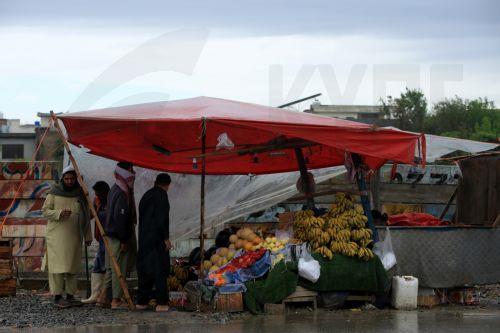 epa12860023 A vendor takes shelter under a waterproof plastic sheet during a rainy day in Peshawar, Pakistan, 30 March 2026. At least nine people were killed and several others injured after heavy rains and strong winds caused roof collapses in parts of Khyber Pakhtunkhwa and Punjab, with Bannu among the worst affected. Rescue efforts are ongoing, and...