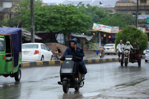 epa12860024 A man covers himself with a plastic raincoat as he rides a motorcycle on a rainy day in Peshawar, Pakistan, 30 March 2026. At least nine people were killed and several others injured after heavy rains and strong winds caused roof collapses in parts of Khyber Pakhtunkhwa and Punjab, with Bannu among the worst affected. Rescue efforts are ongoing,...