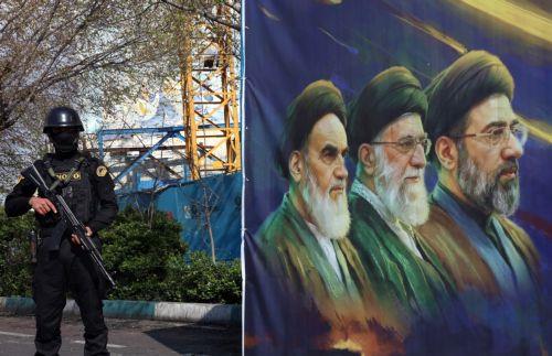 epa12861673 A member of the Iranian security forces stands guard next to a banner showing former and current Iranian supreme leaders, in Tehran, Iran, 31 March 2026. A joint US and Israeli military operation, launched on 28 February, continues to target strategic sites across Iran.  EPA/ABEDIN TAHERKENAREH