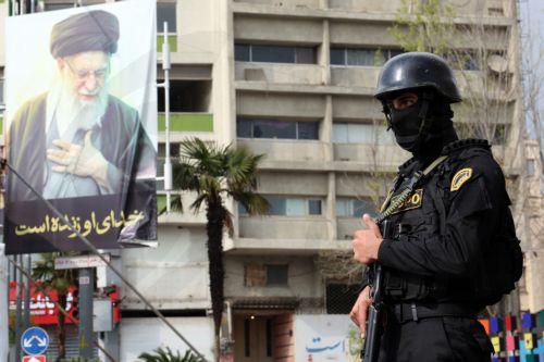 epa12861676 A member of the Iranian security forces stands guard next to a banner showing of late Iranian supreme leader Ayatollah Ali Khamenei, in Tehran, Iran, 31 March 2026. A joint US and Israeli military operation, launched on 28 February, continues to target strategic sites across Iran.  EPA/ABEDIN TAHERKENAREH
