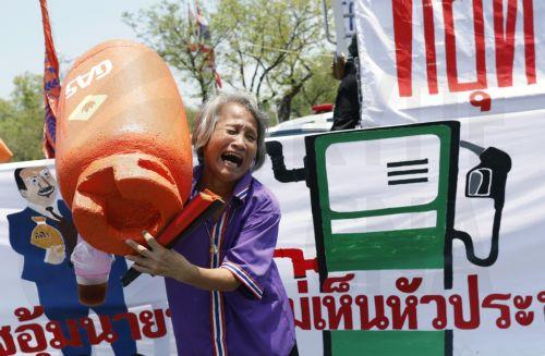 epa12865752 A protester reacts while holding a mock liquefied petroleum gas (LPG) cooking cylinder during a demonstration against the soaring fuel prices and living costs, outside Government House, in Bangkok, Thailand, 02 April 2026. Labor networks and civil society groups staged the protest against oil price hikes, urging the government to address the...