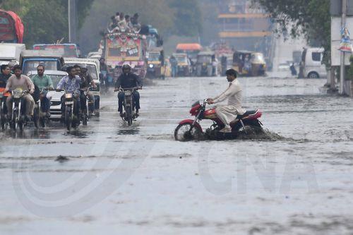 epa12866246 People drive cars and motorcycles along a flooded road following heavy rainfall in Karachi, Pakistan, 02 April 2026. Heavy rain lashed Karachi and surrounding areas, prompting local authorities to declare an emergency as a westerly weather system brought intermittent showers, strong winds, and isolated heavy downpours across the city. ...