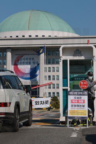 epa12874306 A police officer controls the entry of vehicles at the entrance of the National Assembly in Seoul, South Korea, 08 April 2026, as the government launched a two-day vehicle rotation system in the public sector that allows only cars with even-numbered plates to be driven for the day. The move is part of the government's efforts to curb energy...