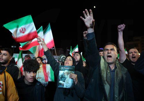 epa12874349 Iranians wave flags and raise their fists during a demonstration following the announcement of a two-week ceasefire at Enghelab Square in Tehran, Iran, 08 April 2026. Iran and the USA agreed to the two-week truce to halt military operations and keep the Strait of Hormuz open for oil and gas shipments, with formal peace talks set to begin in...