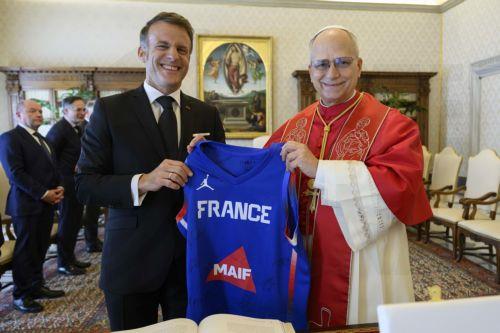epa12880007 A handout picture provided by the Vatican Media shows Pope Leo XIV (R) and French President Emmanuel Macron (L) pose with a basketball jersey during a private audience in Vatican City, 10 April 2026.  EPA/VATICAN MEDIA HANDOUT HANDOUT EDITORIAL USE ONLY/NO SALES