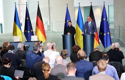 epa12888854 German Chancellor Friedrich Merz (R) and Ukrainian President Volodymyr Zelensky (C) attend a press conference at the Chancellery in Berlin, Germany, 14 April 2026. Following the Hungarian elections on 12 April, the German government expects that the EU’s 90 billion euro loan package for Ukraine will be unblocked swiftly.  EPA/HANNIBAL HANSCHKE