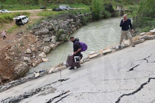 epaselect epa12900333 Displaced people walk across a destroyed bridge as they return to their villages, in the village of Tayr Felsay, in southern Lebanon, 19 April 2026. Israel and Lebanon have agreed to a 10-day ceasefire, which went into effect at midnight on 16 April.  EPA/WAEL HAMZEH