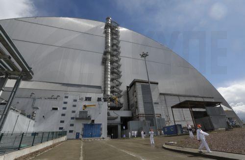 epa12910968 Visitors walk next to the protective shelter over the remains of the nuclear reactor Unit 4 at Chernobyl nuclear power plant, in Chernobyl, Ukraine, 23 April 2026 (issued 24 April 2026). Ukraine will mark the 40th anniversary of the Chernobyl disaster on 26 April 2026. The explosion of reactor 4 of the Chernobyl nuclear power plant in the early...