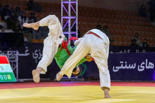epa12916005 An Afghan (green) and Tajik wrestler in action during the International Traditional Wrestling Festival in Kabul, Afghanistan, 26 April 2026. An international traditional wrestling tournament was held in Kabul, where around 160 athletes from seven countries competed over three days across multiple weight categories.  EPA/SAMIULLAH POPAL