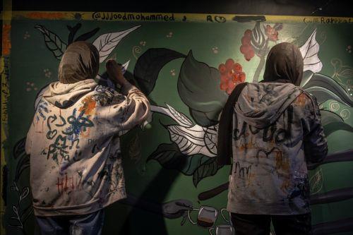 epa12922459 Palestinian Joud Mohammed (R), 18, and Rahaf Al-Halabi (L), 18, paint together inside a small cafe in Gaza City, 29 April 2026. The two teenagers use their artwork as a means of self-expression and to provide financial support for their families amid ongoing economic hardship. With Gaza's educational system largely paralyzed since the outbreak...