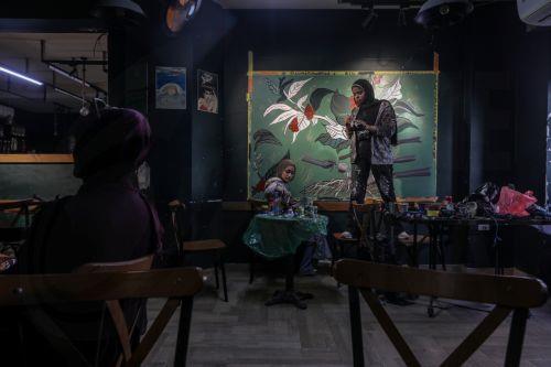 epa12922463 Palestinian Joud Mohammed (R), 18, and Rahaf Al-Halabi (L), 18, paint together inside a small cafe in Gaza City, 29 April 2026. The two teenagers use their artwork as a means of self-expression and to provide financial support for their families amid ongoing economic hardship. With Gaza's educational system largely paralyzed since the outbreak...