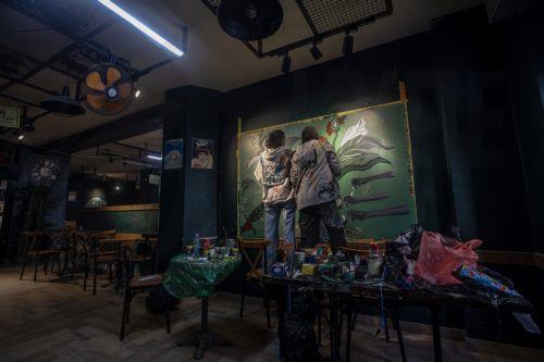 epa12922464 Palestinian Joud Mohammed (R), 18, and Rahaf Al-Halabi (L), 18, paint together inside a small cafe in Gaza City, 29 April 2026. The two teenagers use their artwork as a means of self-expression and to provide financial support for their families amid ongoing economic hardship. With Gaza's educational system largely paralyzed since the outbreak...