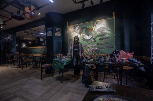 epa12922487 Palestinian Joud Mohammed, 18, poses for a photograph inside a small cafe in Gaza City, 29 April 2026. Palestinian teenagers Joud Mohammed and Rahaf Al-Halabi use their artwork as a means of self-expression and to provide financial support for their families amid ongoing economic hardship. With Gaza's educational system largely paralyzed since...
