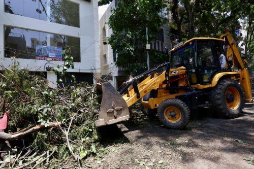 epa12923717 Heavy machinery clears trees uprooted and broken branches following heavy overnight rain in Bangalore, India, 30 April 2026. The city was affected by over 111.5 mm of rainfall and strong winds on 29 April. More than 170 trees were uprooted, and many branches were broken due to lightning and thunderstorms. At least 10 people lost their lives in...