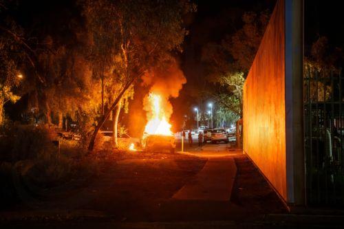 epa12925501 A police vehicle burns as community members clash with authorities outside Alice Springs Hospital in Alice Springs, Australia, 30 April 2026 (issued 01 May 2026). The riot erupted following the arrest of a man, who is accused of the abduction and murder of five-year-old Kumanjayi Little Baby.  EPA/RHETT HAMMERTON  AUSTRALIA AND NEW ZEALAND OUT