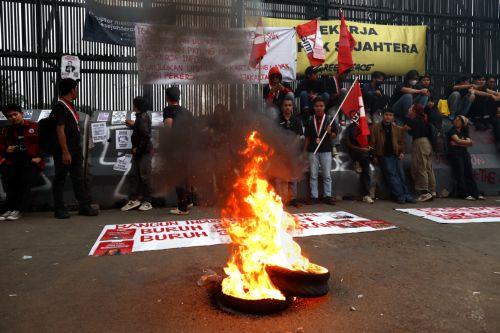 epa12926133 Protesters burn used tires during a protest marking International Worker's Day outside the parliament building in Jakarta, Indonesia, 01 May 2026. Thousands of workers staged a protest against imperialism and oligarchy, demanding better employment law and fair wages.  EPA/MAST IRHAM