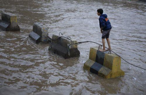 epa12929029 A youth stands on a concrete barrier in a flooded street following torrential rainfall in Sana'a, Yemen, 02 May 2026. Yemen's National Center of Meteorology and Early Warning has warned of further heavy rains and possible flooding across much of the country.  EPA/YAHYA ARHAB