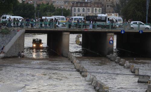 epa12929031 A vehicle (L) drives through a flooded street following torrential rainfall in Sana'a, Yemen, 02 May 2026. Yemen's National Center of Meteorology has warned of further heavy rains and subsequent flooding across much of the country.  EPA/YAHYA ARHAB