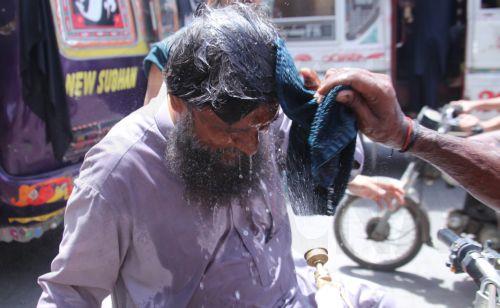 epa12931537 A volunteer sprays water on people during a heatwave in Karachi, Pakistan, 04 May 2026. The Pakistan Meteorological Department has issued a heatwave alert for Karachi, warning that temperatures could rise to around 41 degrees Celsius in the coming days.  EPA/REHAN KHAN