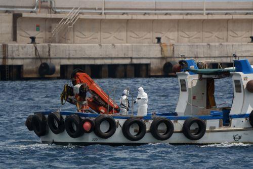 epa12947800 Personnel wearing protective gear on a support vessel head toward the MV Hondius cruise ship, which was affected by several hantavirus cases, at the Port of Granadilla de Abona in Tenerife, Spain, 11 May 2026. Authorities prepared to disembark the last passengers and crew members, who were expected to be repatriated from Tenerife South Airport. ...