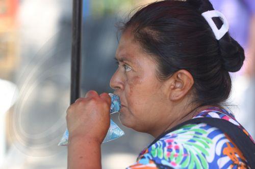 epa12952053 A woman drinks water to cope with a heat wave, which is causing 'extreme temperatures' exceeding 40 degrees Celsius, in San Salvador, El Salvador, 12 May 2026.  EPA/Javier Aparicio