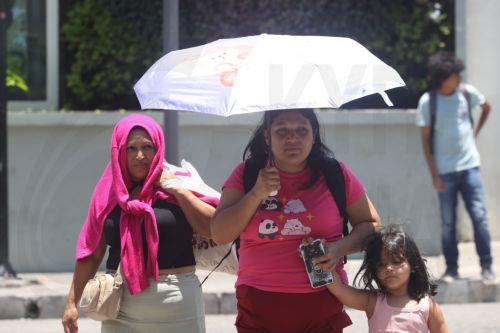 epa12952058 A woman uses an umbrella for relief from a heat wave, which is causing 'extreme temperatures' exceeding 40 degrees Celsius, in San Salvador, El Salvador, 12 May 2026.  EPA/Javier Aparicio