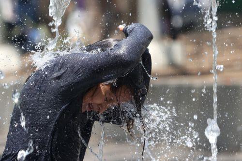 epa12952057 A child cools off in a fountain during a heat wave, which is causing 'extreme temperatures' exceeding 40 degrees Celsius, in San Salvador, El Salvador, 12 May 2026.  EPA/Javier Aparicio