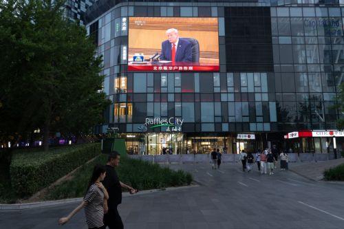 epa12957044 People walk in front of a TV screen broadcasting US President Donald Trump's visit, in Beijing, China, 14 May 2026. US President Trump is in Beijing for a high-stakes state visit running through 15 May, marking his first return to the mainland since 2017.  EPA/JESSICA LEE