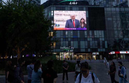 epa12957048 People gather to watch a TV broadcast of US President Donald Trump's visit, in Beijing, China, 14 May 2026. US President Trump is in Beijing for a high-stakes state visit running through 15 May, marking his first return to the mainland since 2017.  EPA/JESSICA LEE