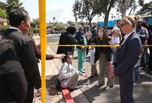 epa12972648 A woman (3-R) holding her child reacts to San Diego Mayor Todd Gloria (L) in response to the active shooting incident in San Diego, California, USA, 18 May 2026. Police agencies from across San Diego County responded to an active shooter incident at the Islamic Center of San Diego in the Clairemont neighborhood. Three people were killed,...
