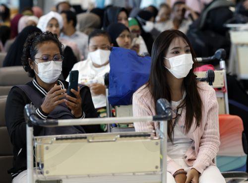 epa12977390 International flight travelers wear protective face masks at Suvarnabhumi Airport in Samut Prakan province, Thailand, 20 May 2026. Thailand's Public Health Ministry has tightened its health surveillance measures to closely monitor travellers arriving from countries at high risk for an Ebola virus disease outbreak, aiming to prevent imported...